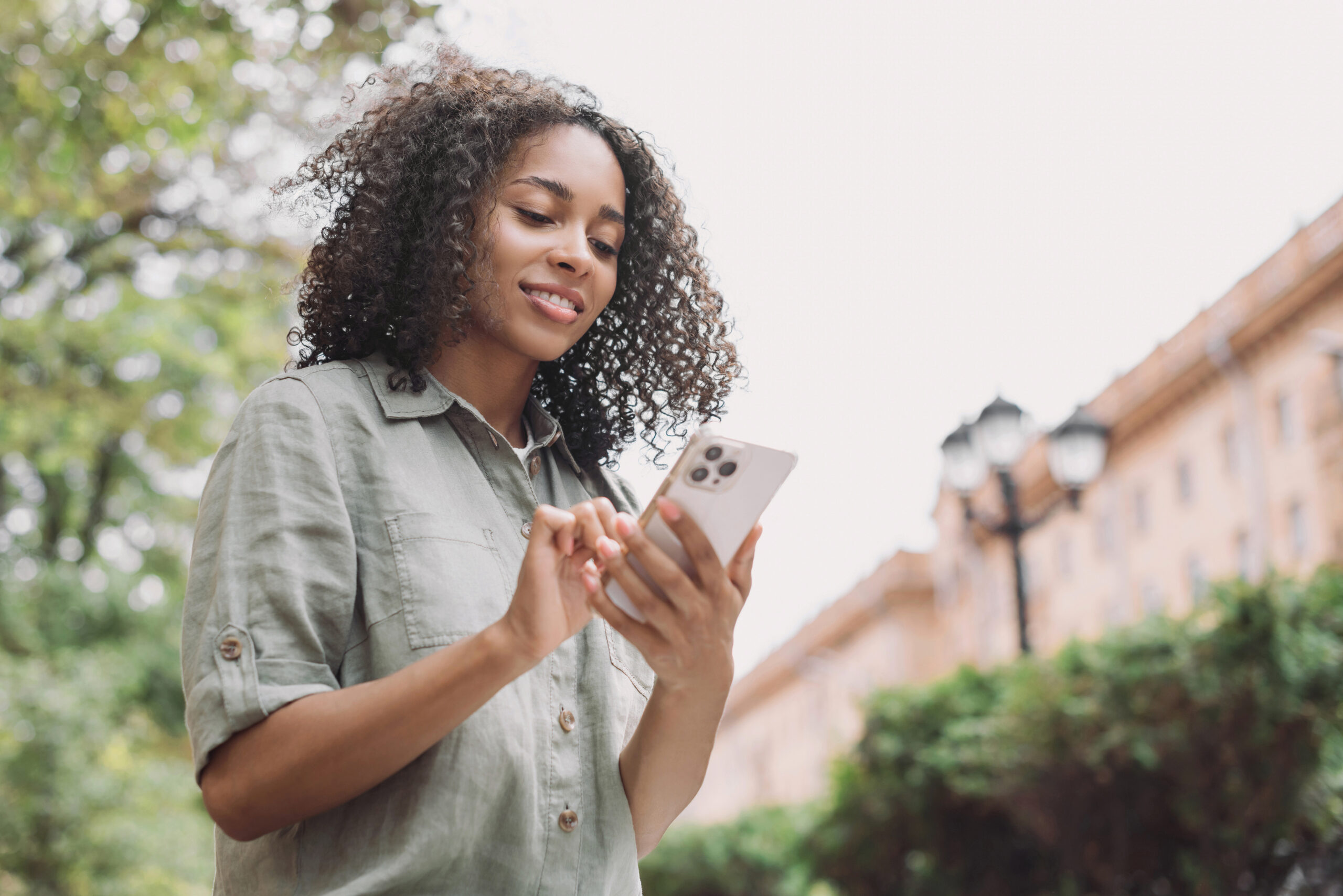 Young beautiful woman using smartphone in a city, Smiling studen